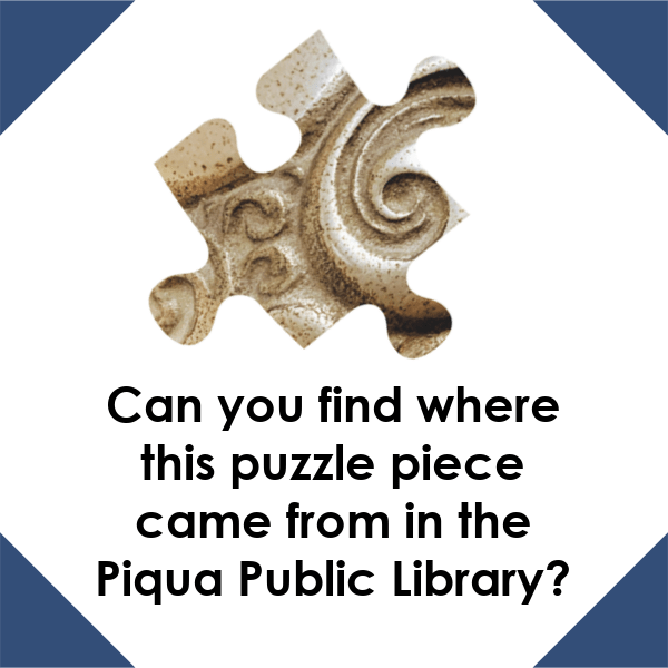 A graphic with a white background and navy blue corners. There is a puzzle piece with gold swirls on it in the center. The black text under the puzzle piece reads "Can you find where this puzzle piece came from in the Piqua Public Library?"